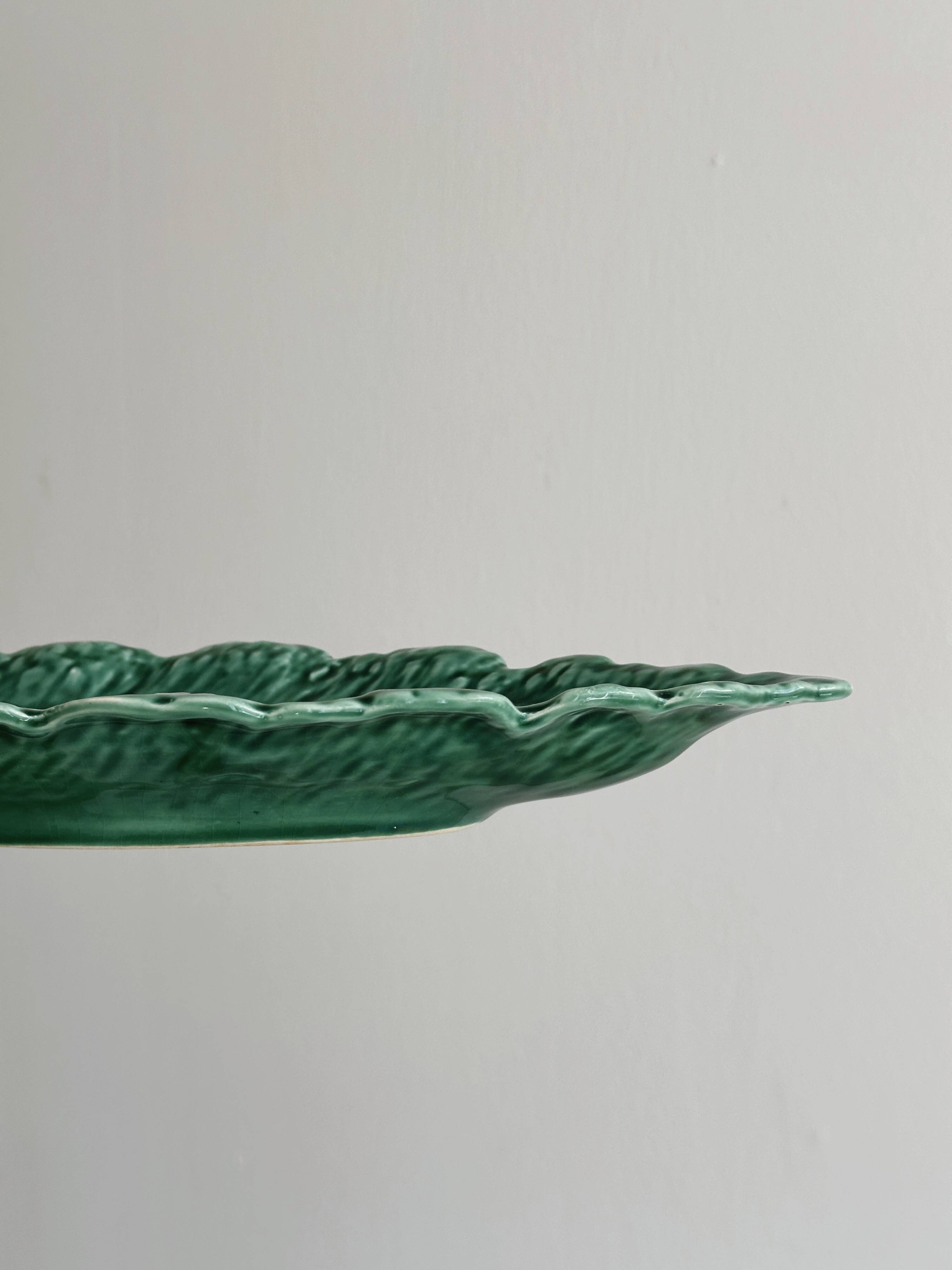 Green earthenware dish in the shape of a leaf