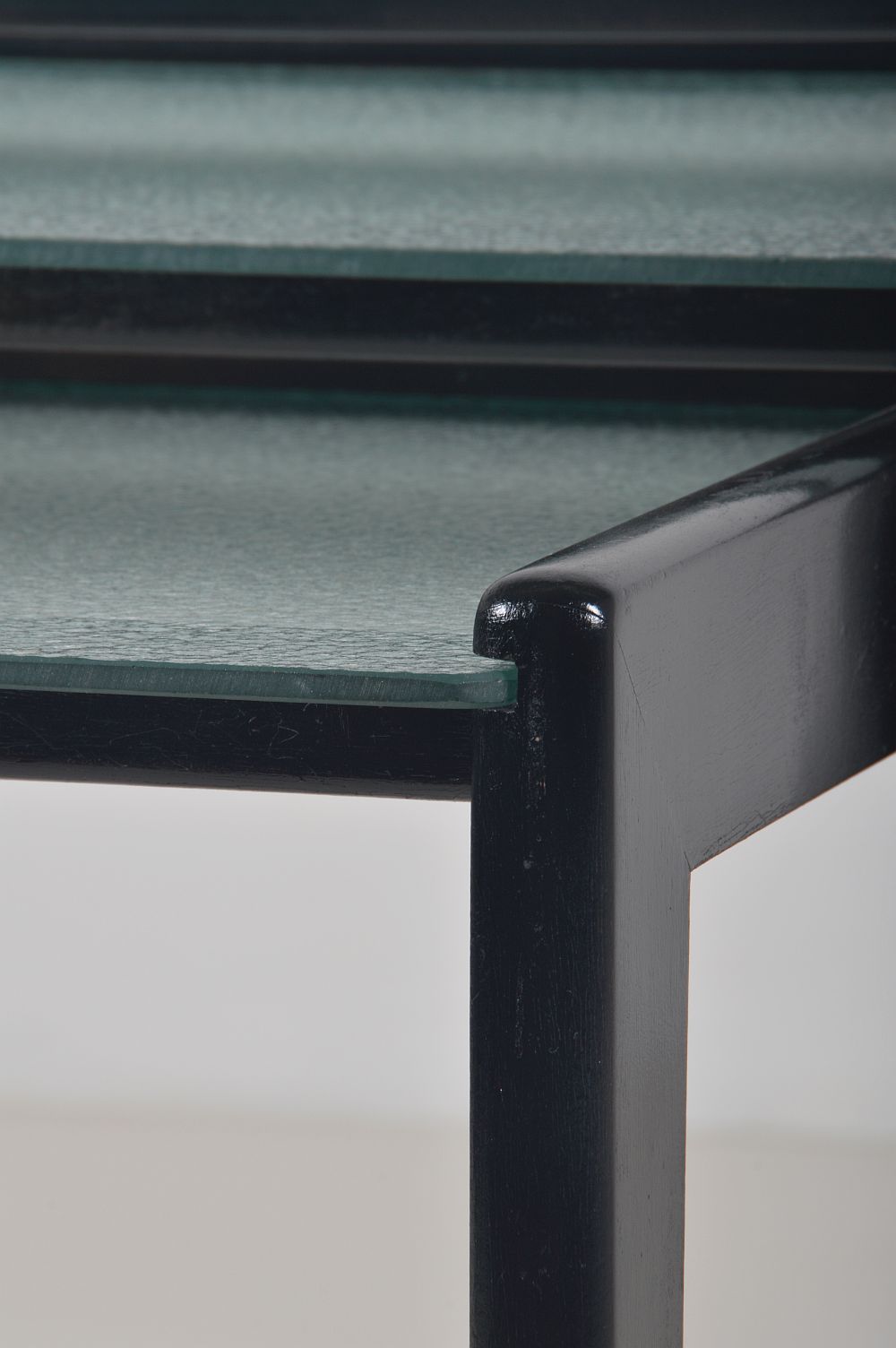 Tables gigognes en bois teinté noir et plateau en verre, années 1960