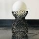 Handcrafted wrought iron lamp with a white opaline globe.