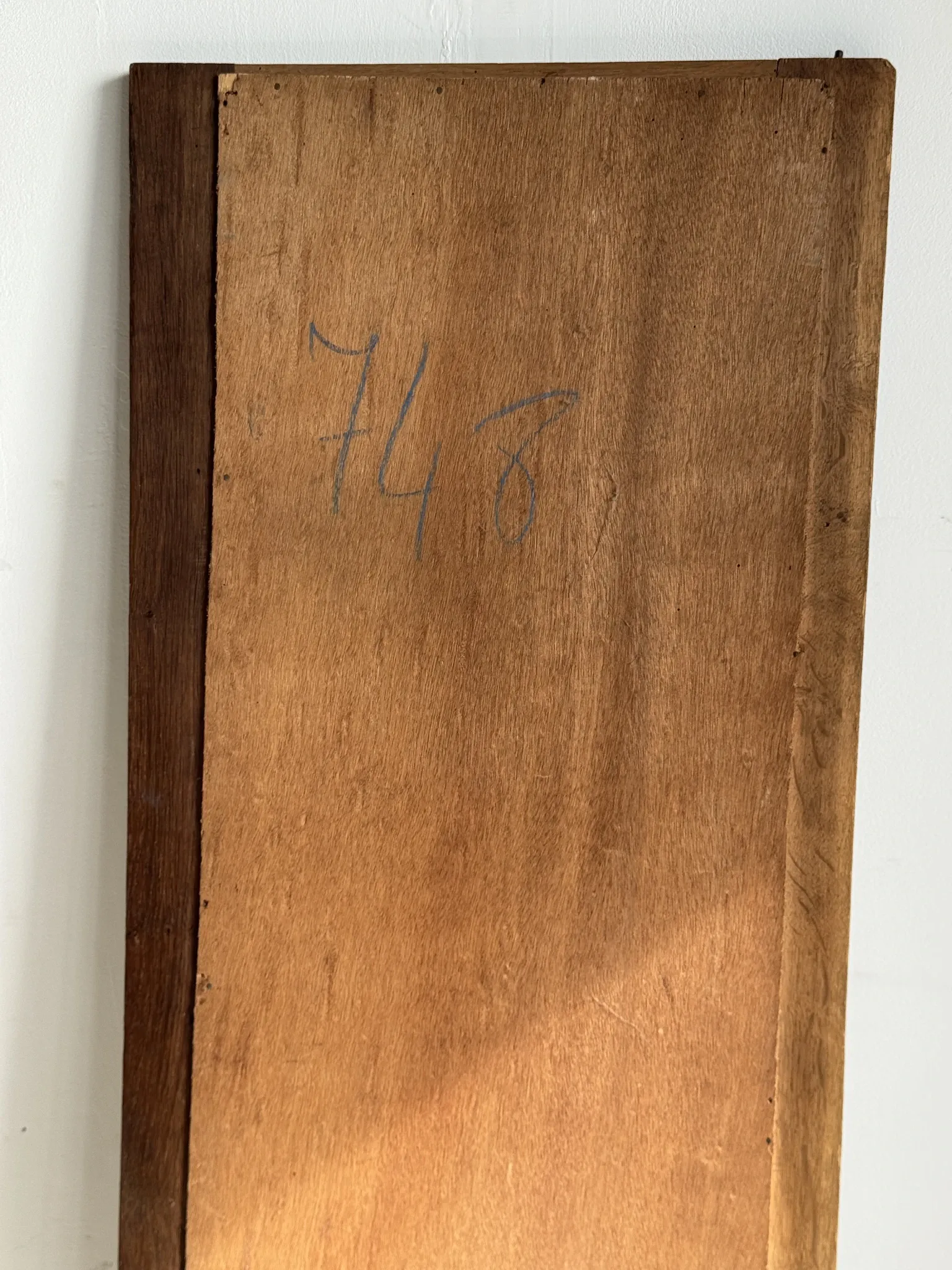 Antique mirror door (left) of a brown oak wardrobe with bevelled glass.