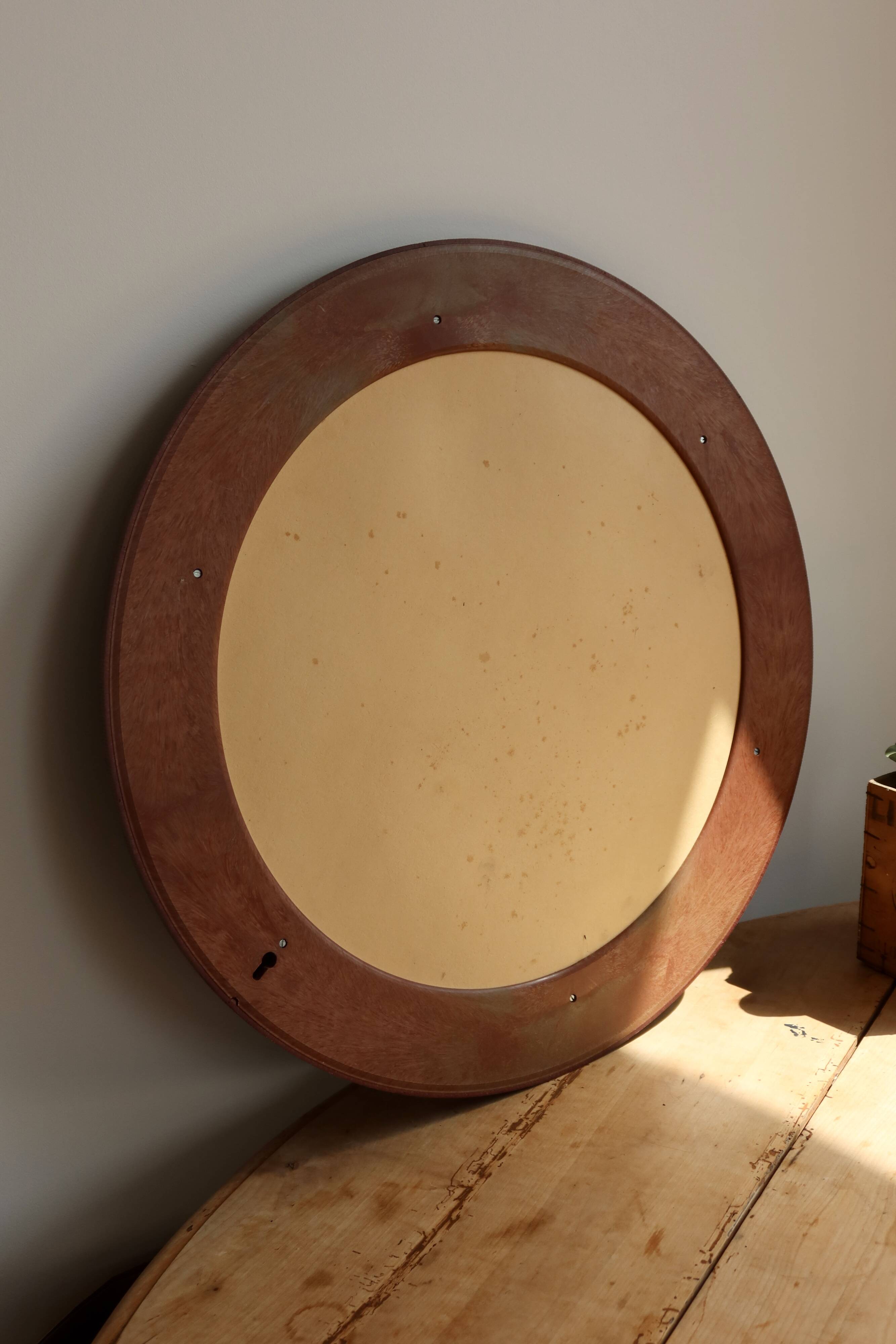 Round vintage mirror with mahogany wood effect frame.