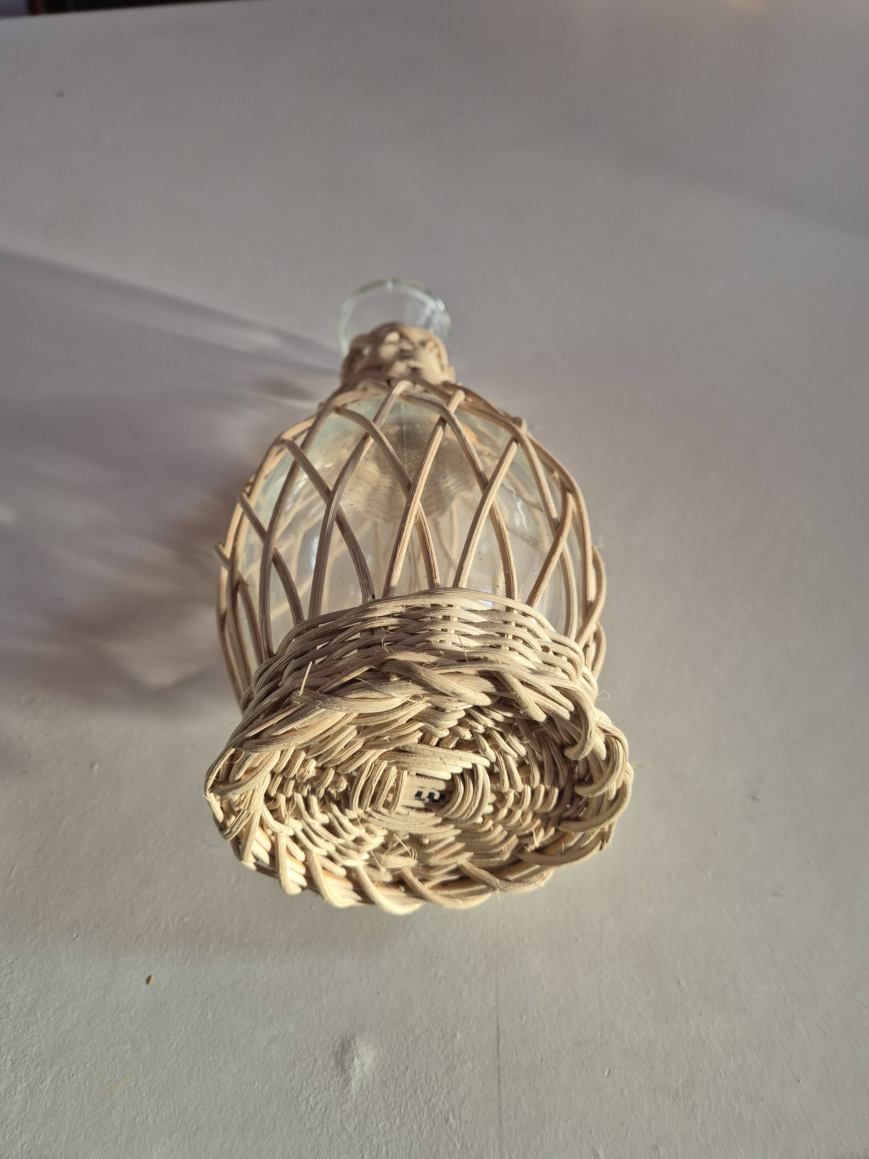 vintage glass vase surrounded by woven rattan
