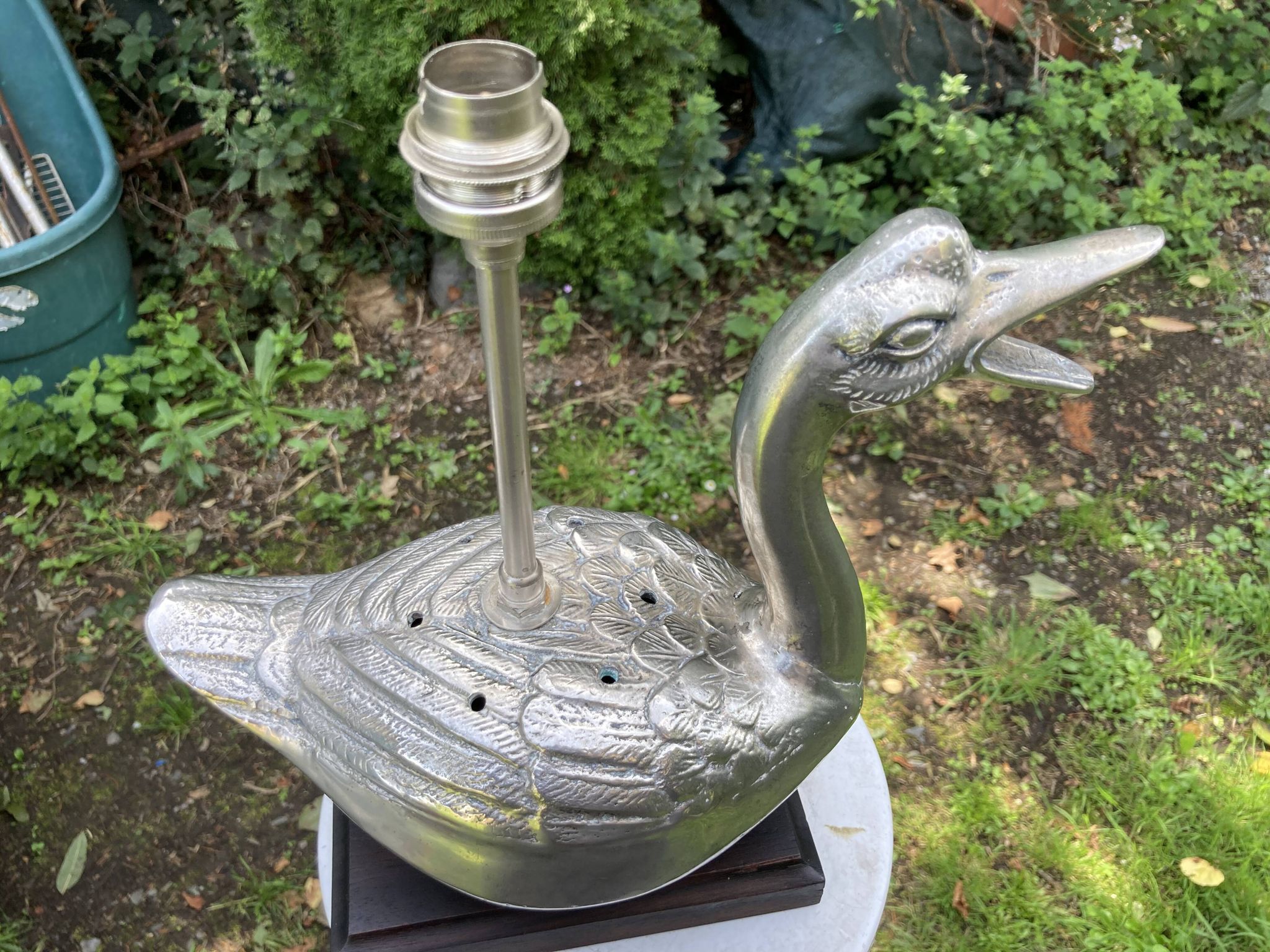 Old vintage lamp representing a duck in silver metal with wooden base