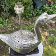 Old vintage lamp representing a duck in silver metal with wooden base