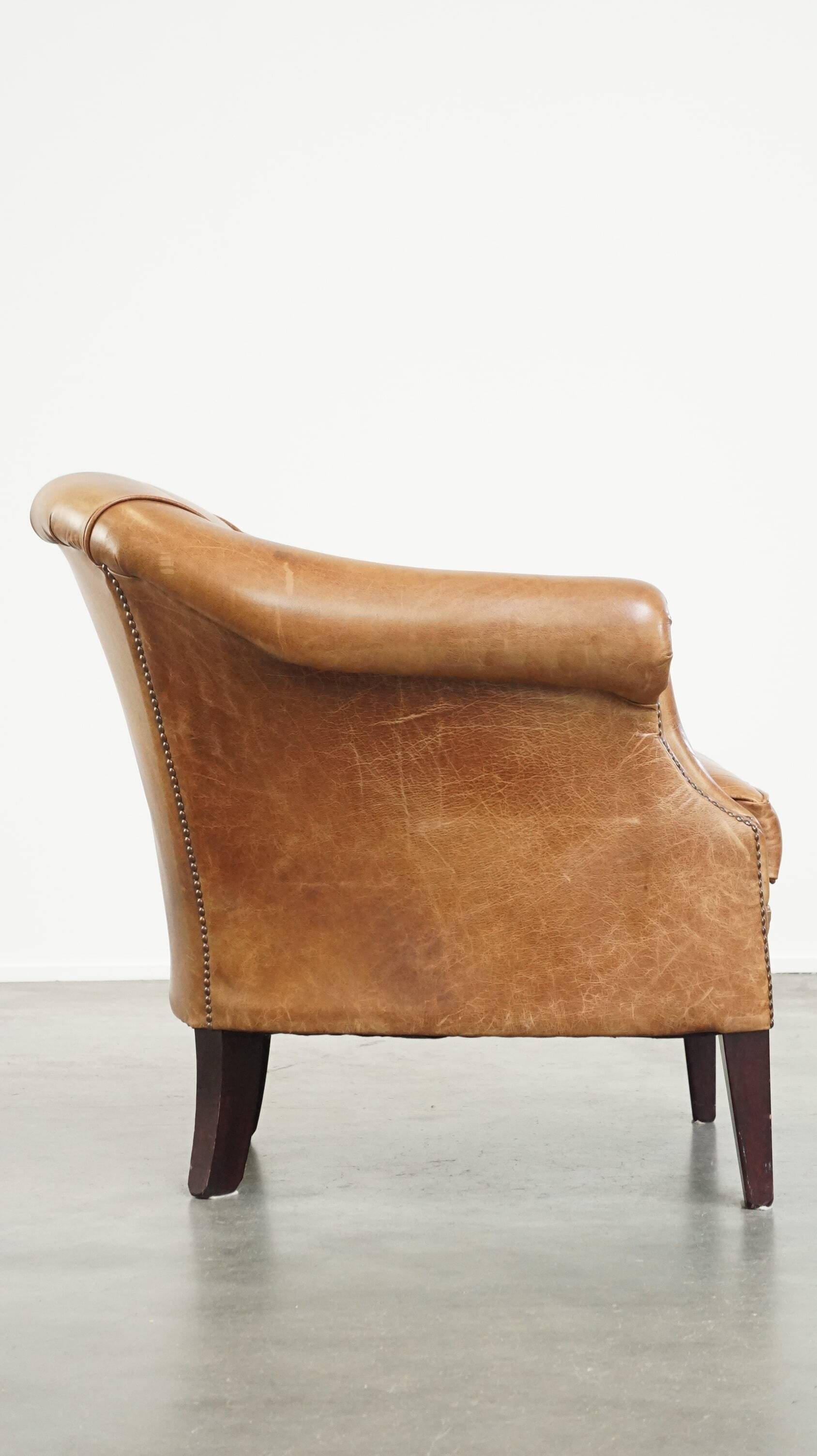 Very comfortable, elegant leather club armchair with a removable seat cushion and timeless design