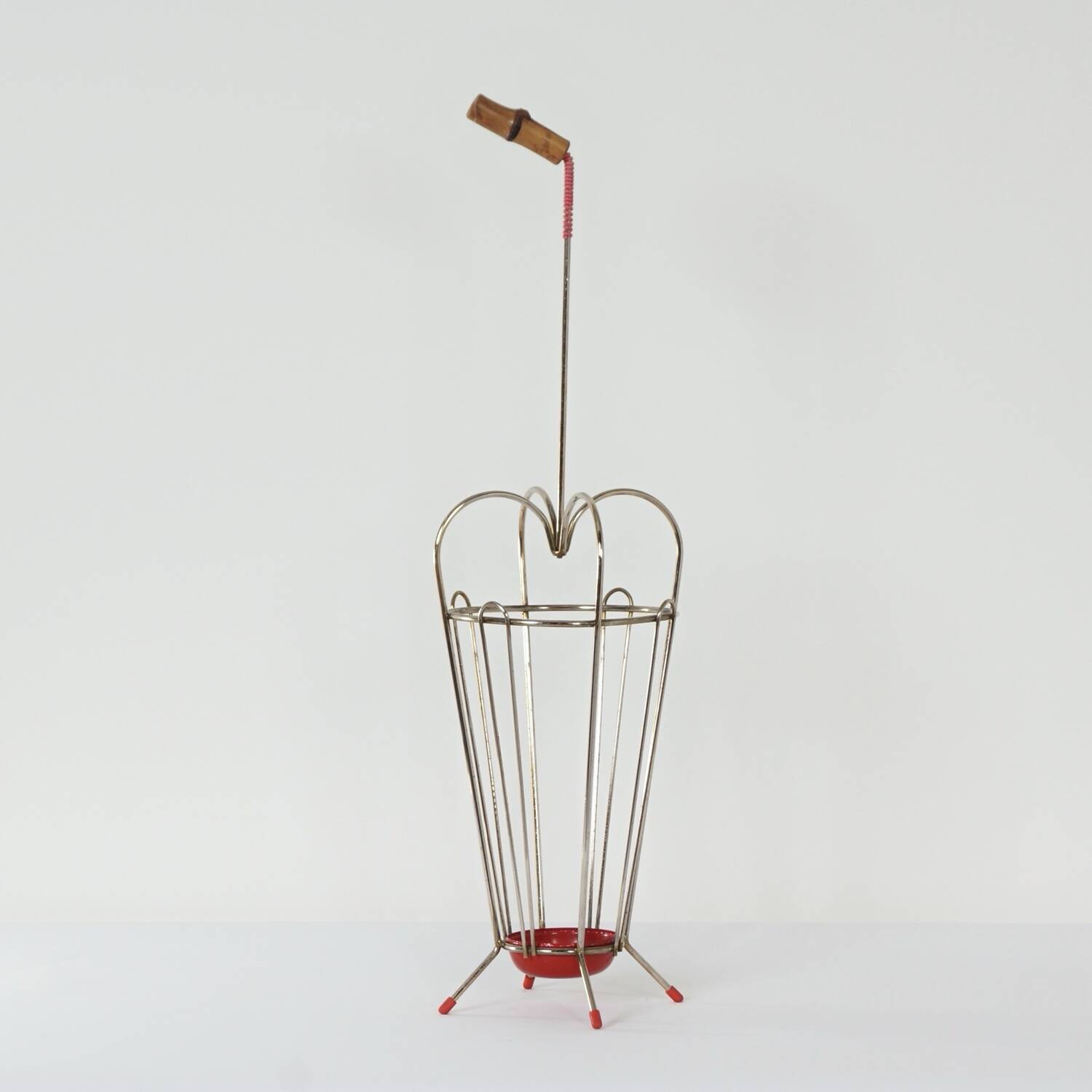 VINTAGE UMBRELLA STAND OF CURVED METAL, RED DETAILS AND A BAMBOO HANDLE, 1950S