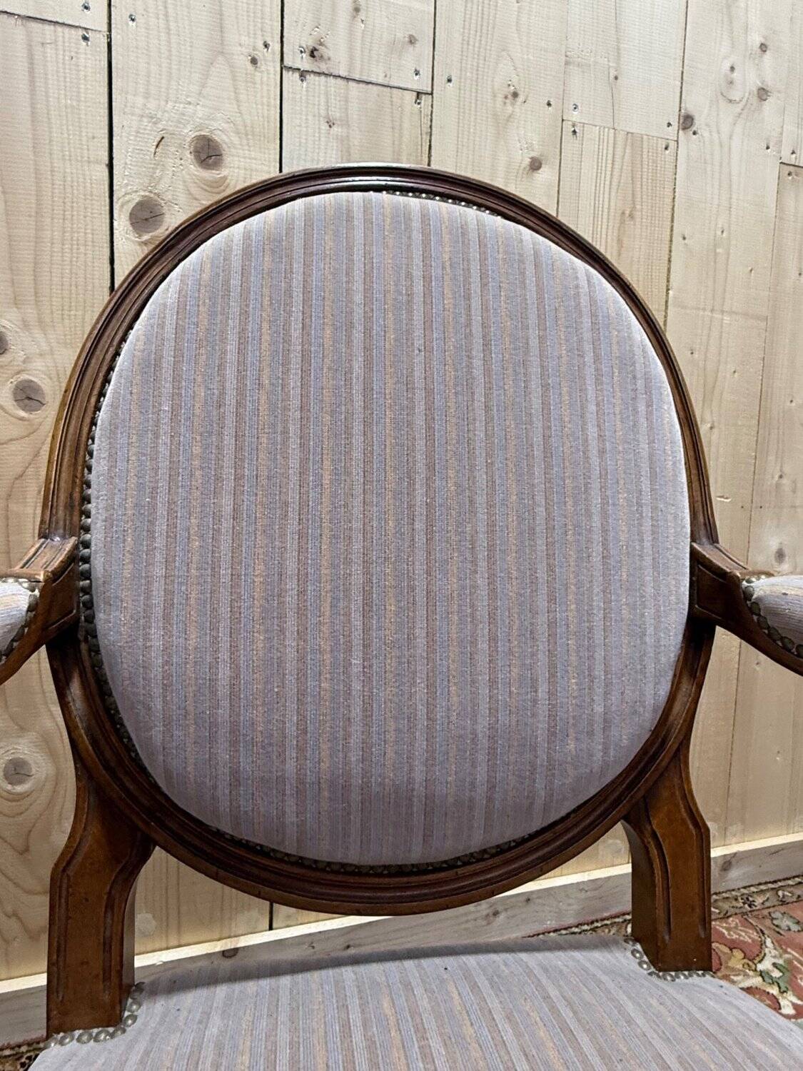 Pair of Louis XVI cabriolet armchairs with medallion backrest.