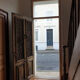 Front door of a house or building in the city centre, with a dolphin door knocker and frame + transom.