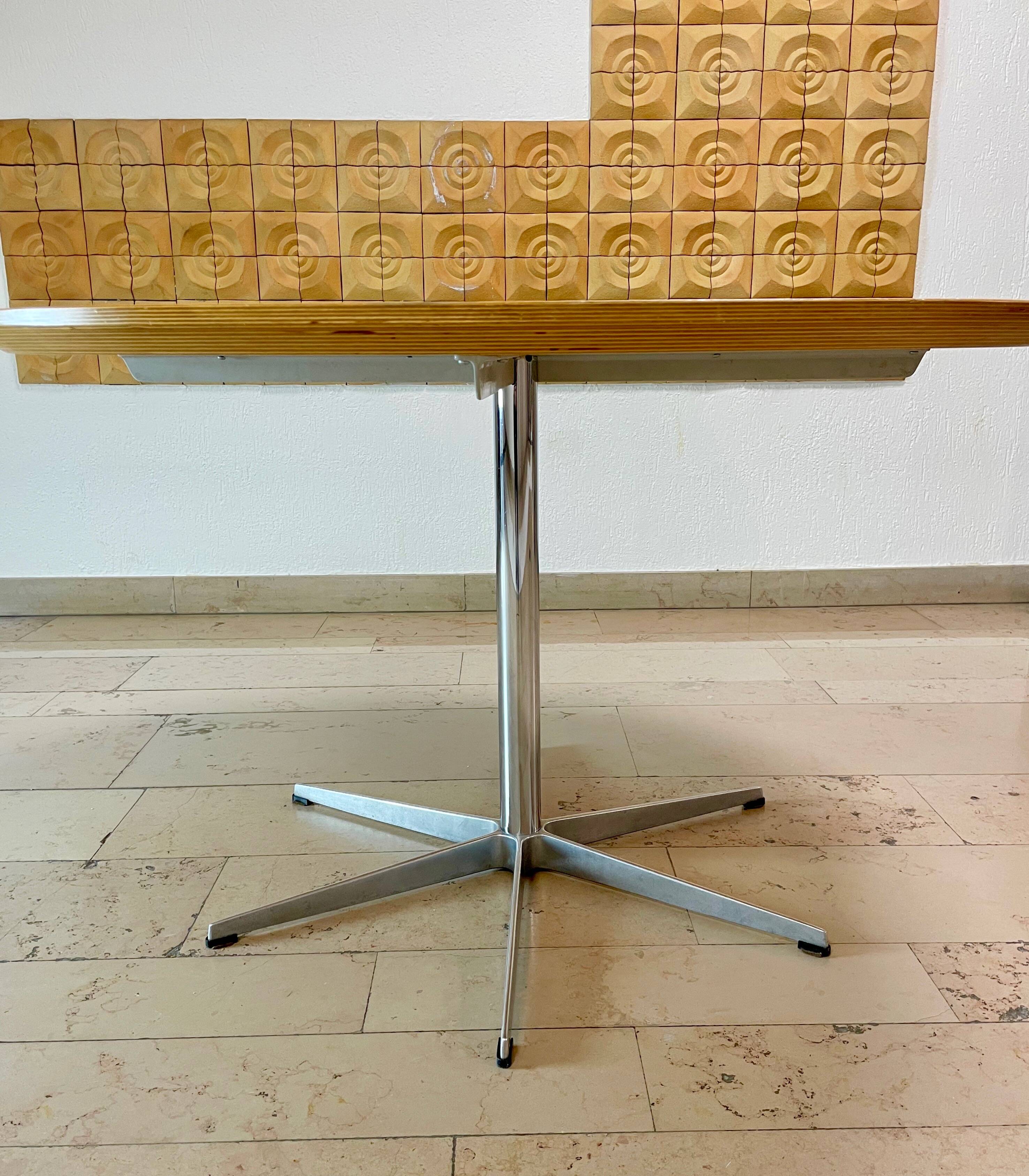 Dining table with a star-shaped six-legged base by Arne Jacobsen for Fritz Hansen.