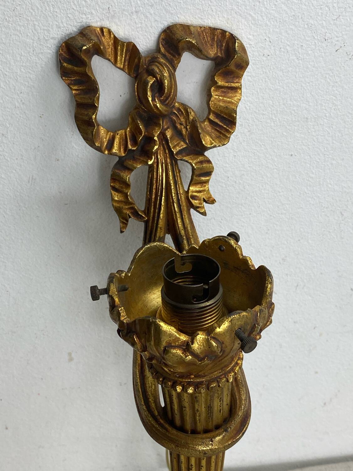 Bronze wall light, decorated with a bow and ribbon.