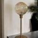 Table lamp with a golden striated globe and a golden base