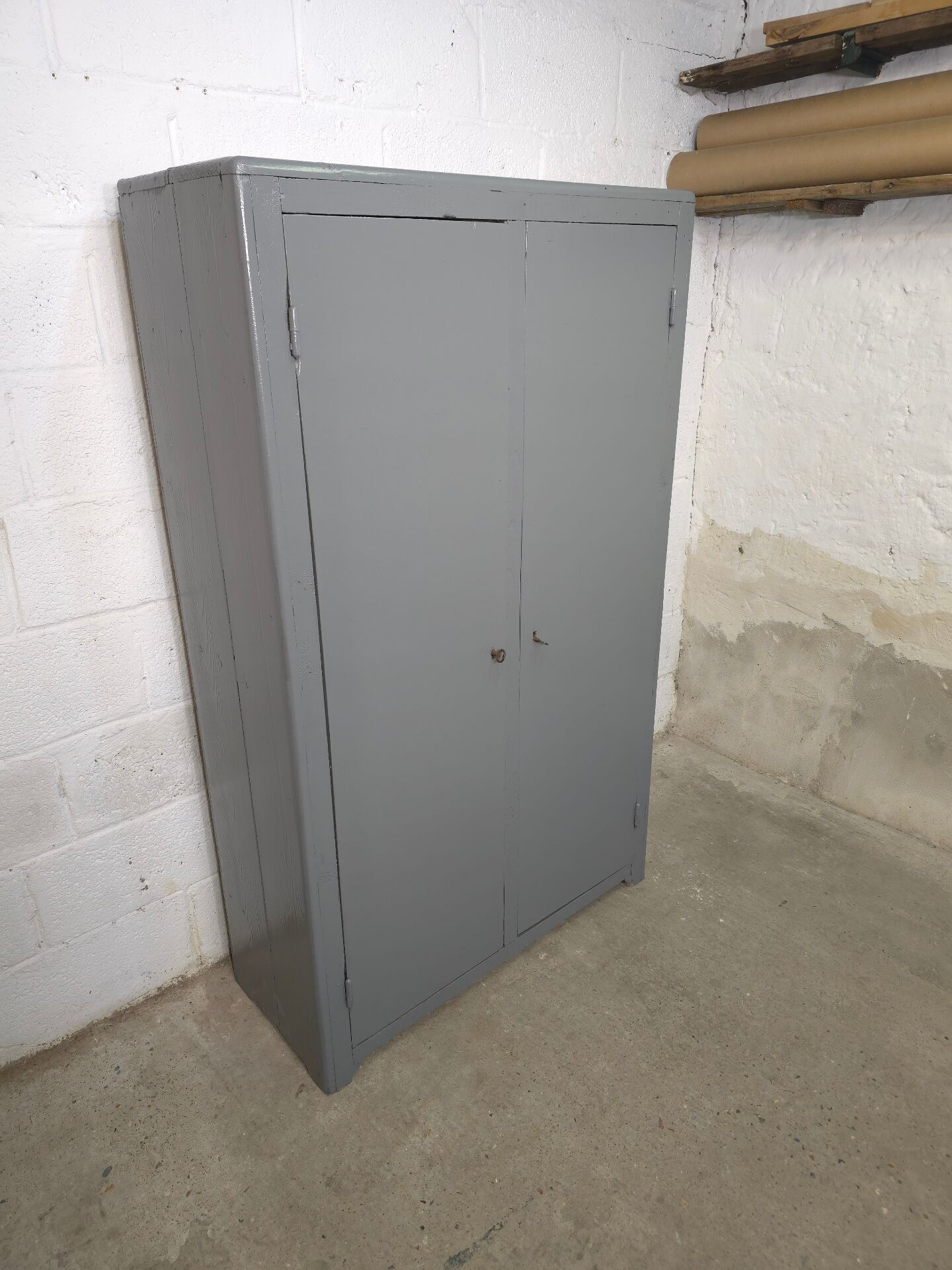 Curved wardrobe workshop locker made of wood repainted in grey.