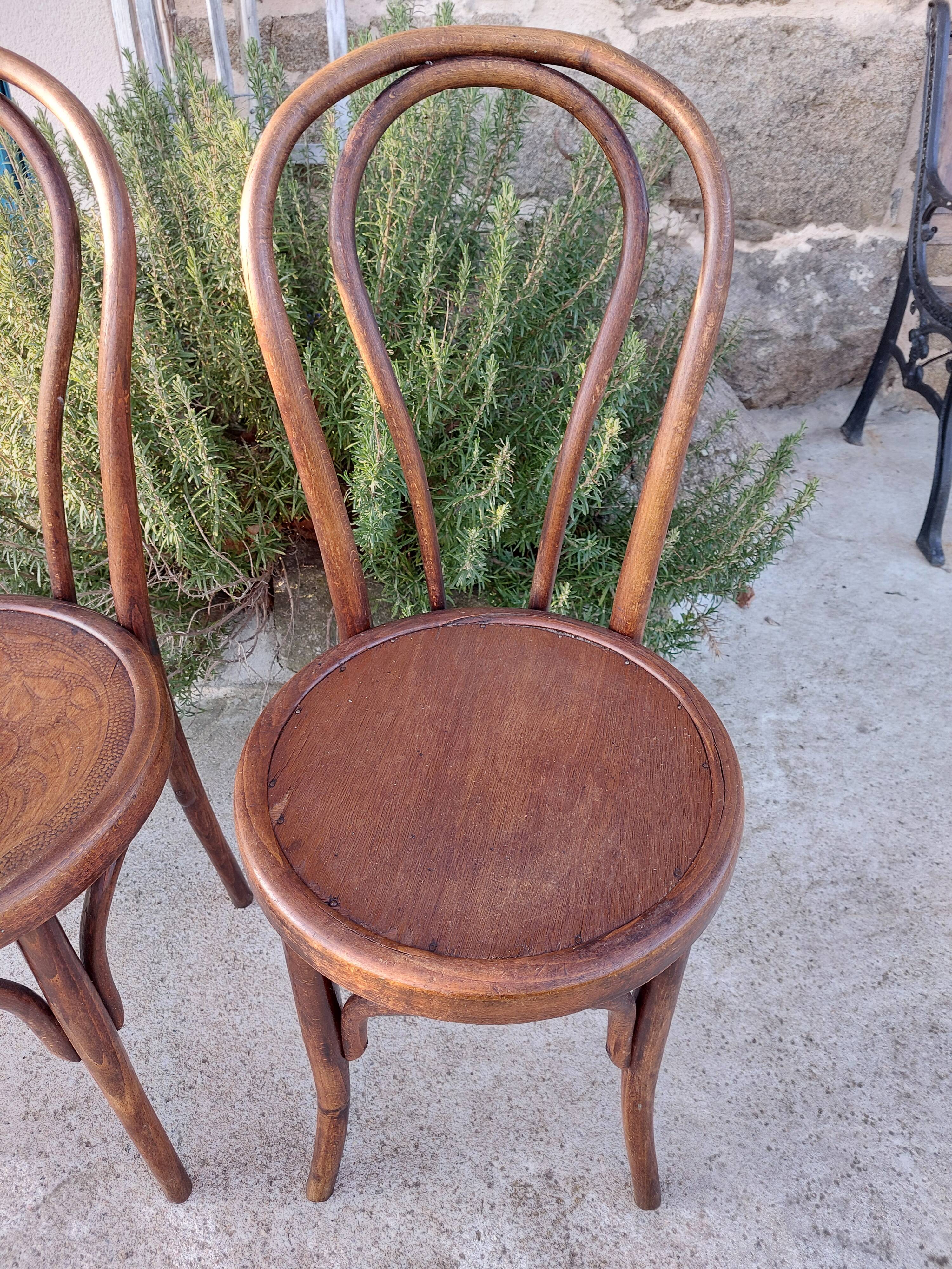 pair of round wooden chairs with a pattern on the seat