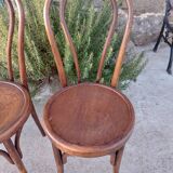 pair of round wooden chairs with a pattern on the seat