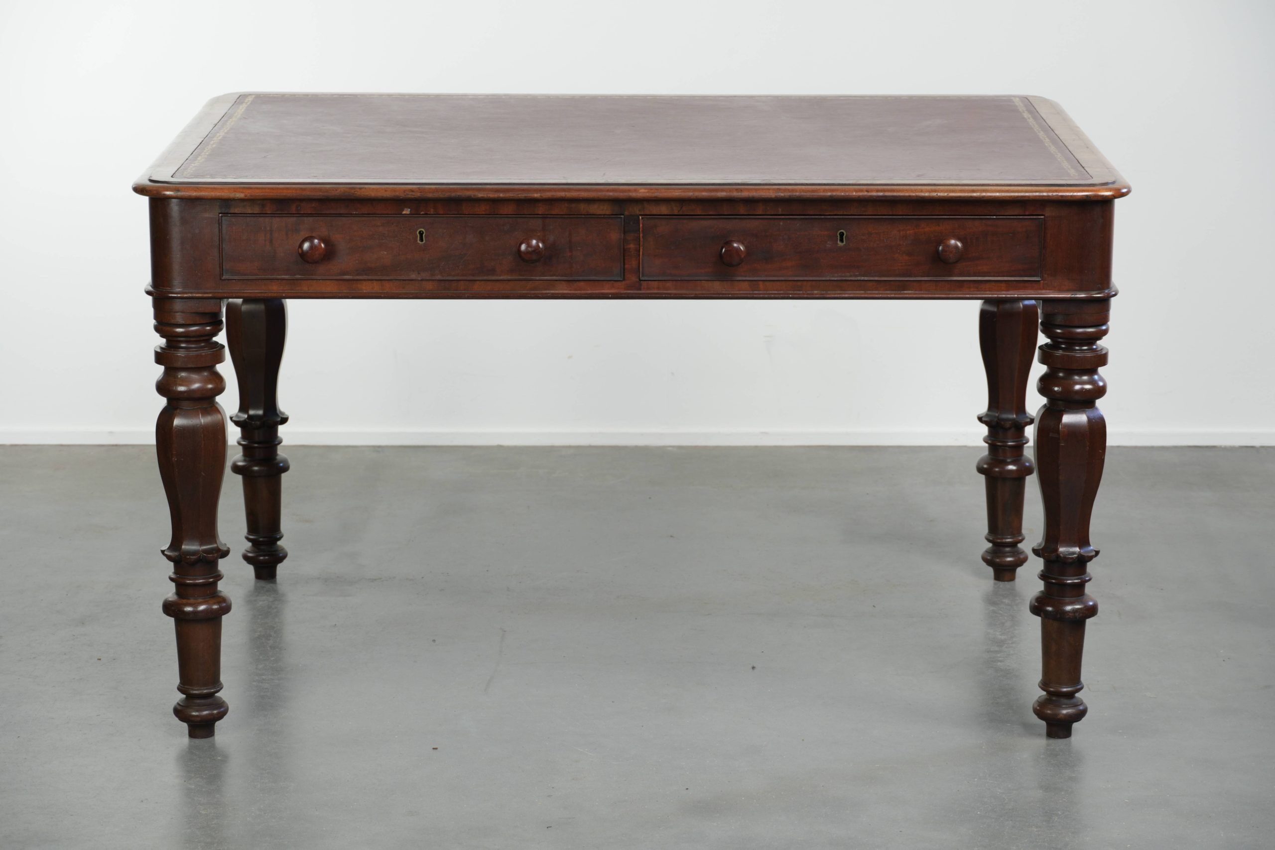 Antique English writing desk from the 19th century with a red leather top
