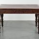 Antique English writing desk from the 19th century with a red leather top