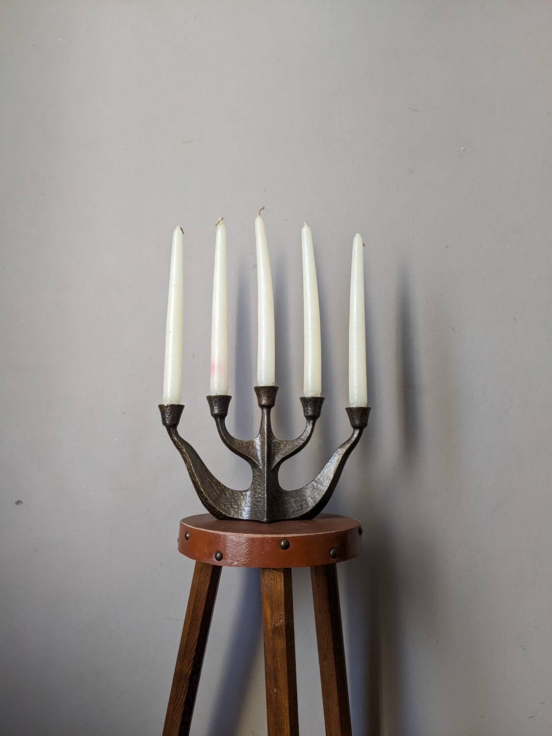 Vintage bronze candlestick chandelier in contemporary Scandinavian design.