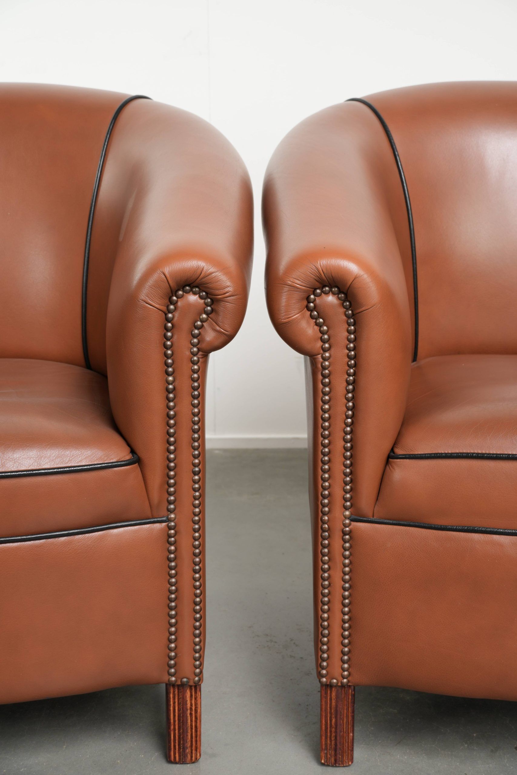 Ensemble de 2 fauteuils club en cuir de vache en bon état dans le style anglais.