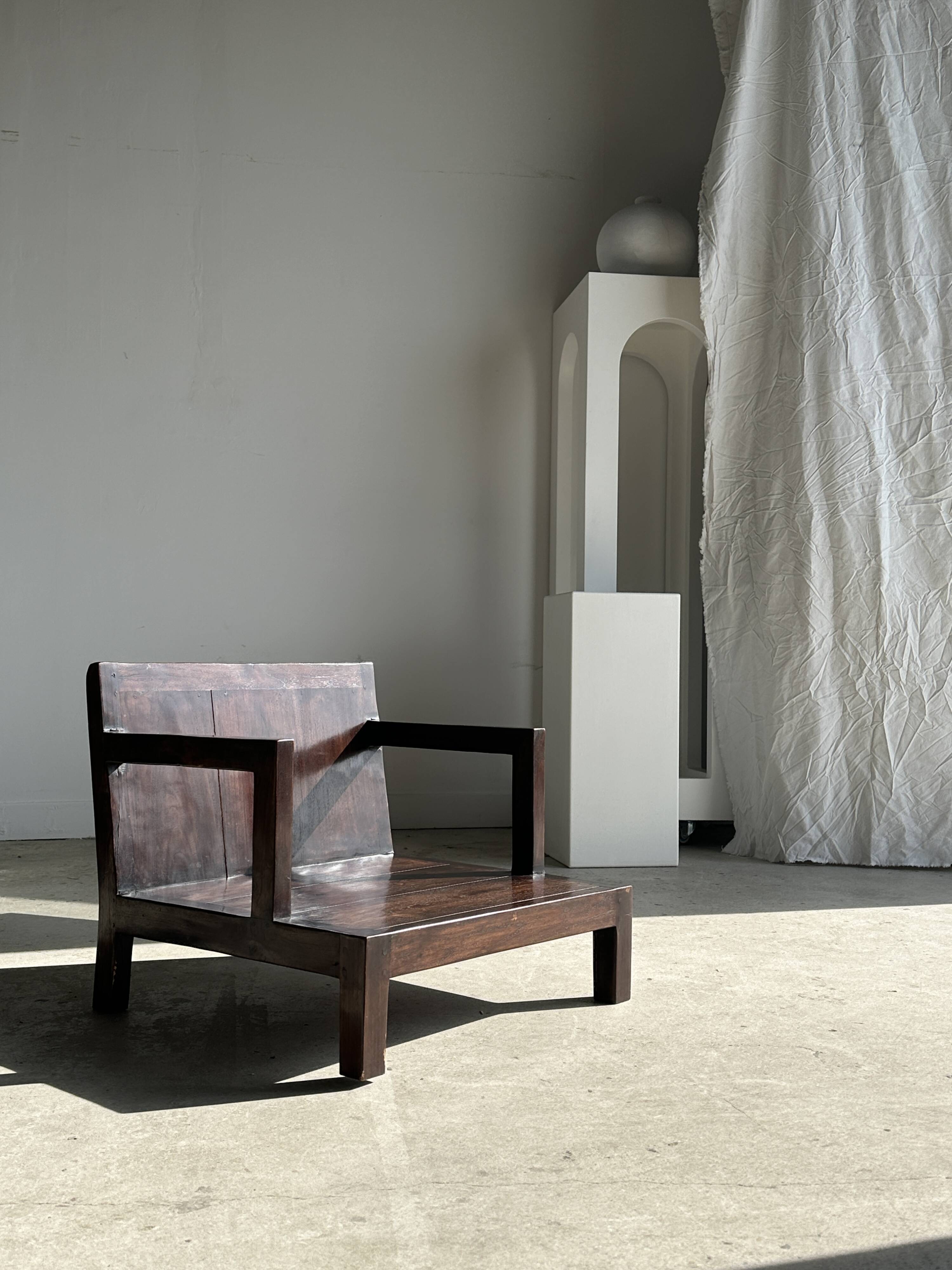 Small low armchair in varnished brown wood