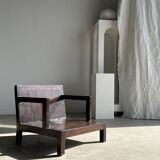 Small low armchair in varnished brown wood