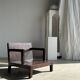 Small low armchair in varnished brown wood