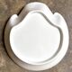 Small, shallow porcelain dish shaped like a seashell