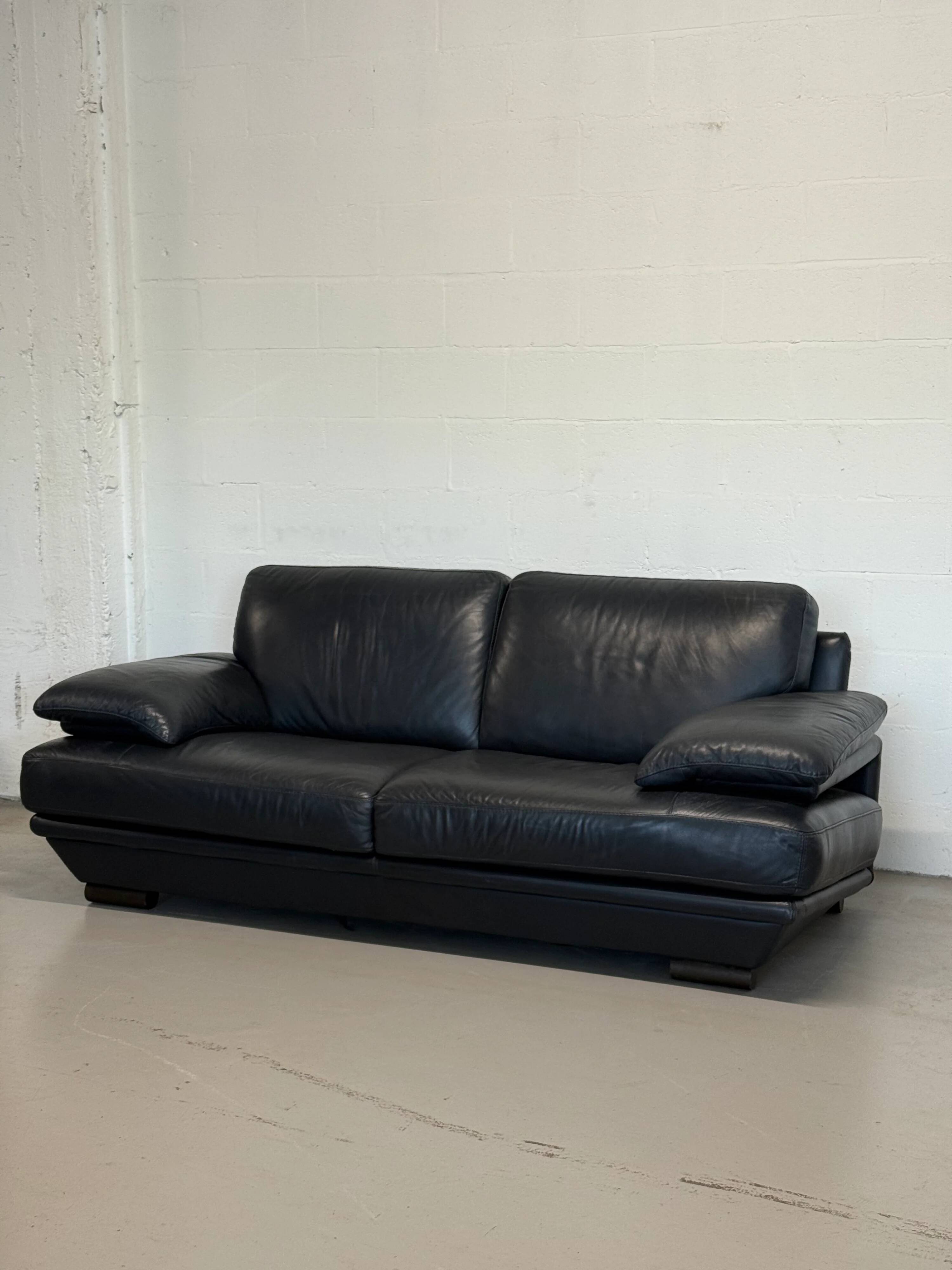 Two-seater Natuzzi sofa in navy blue leather.