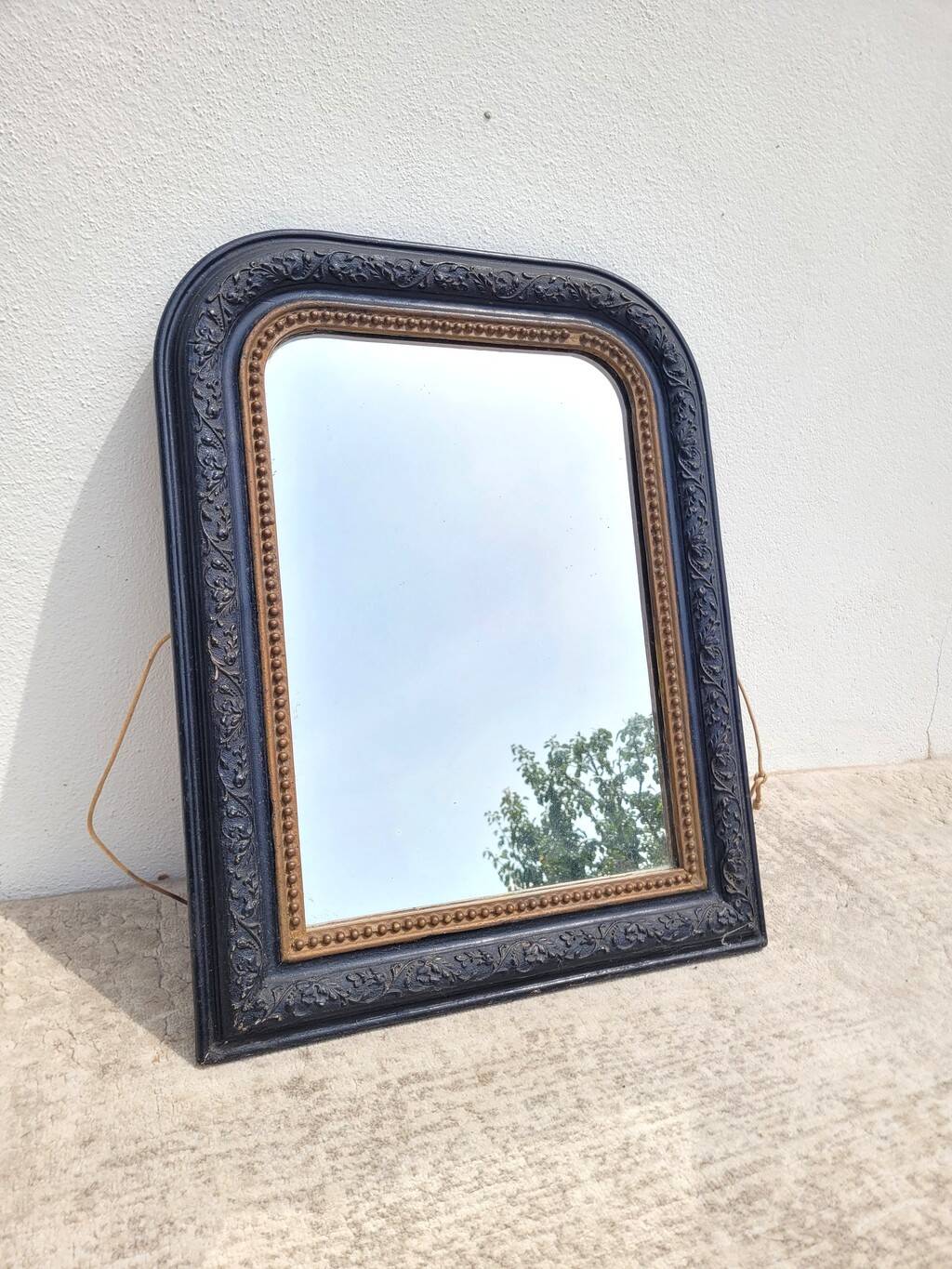 Antique mirror in Napoléon III style, blackened with beaded frieze, 42x55cm.