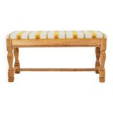 Vintage oak bench with striped linen fabric in a country style.