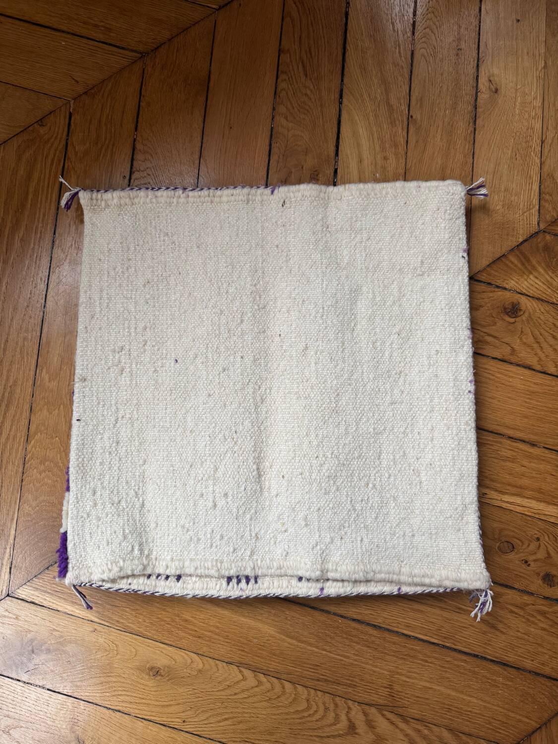 Square cushion cover with a checkered pattern.