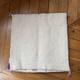 Square cushion cover with a checkered pattern.