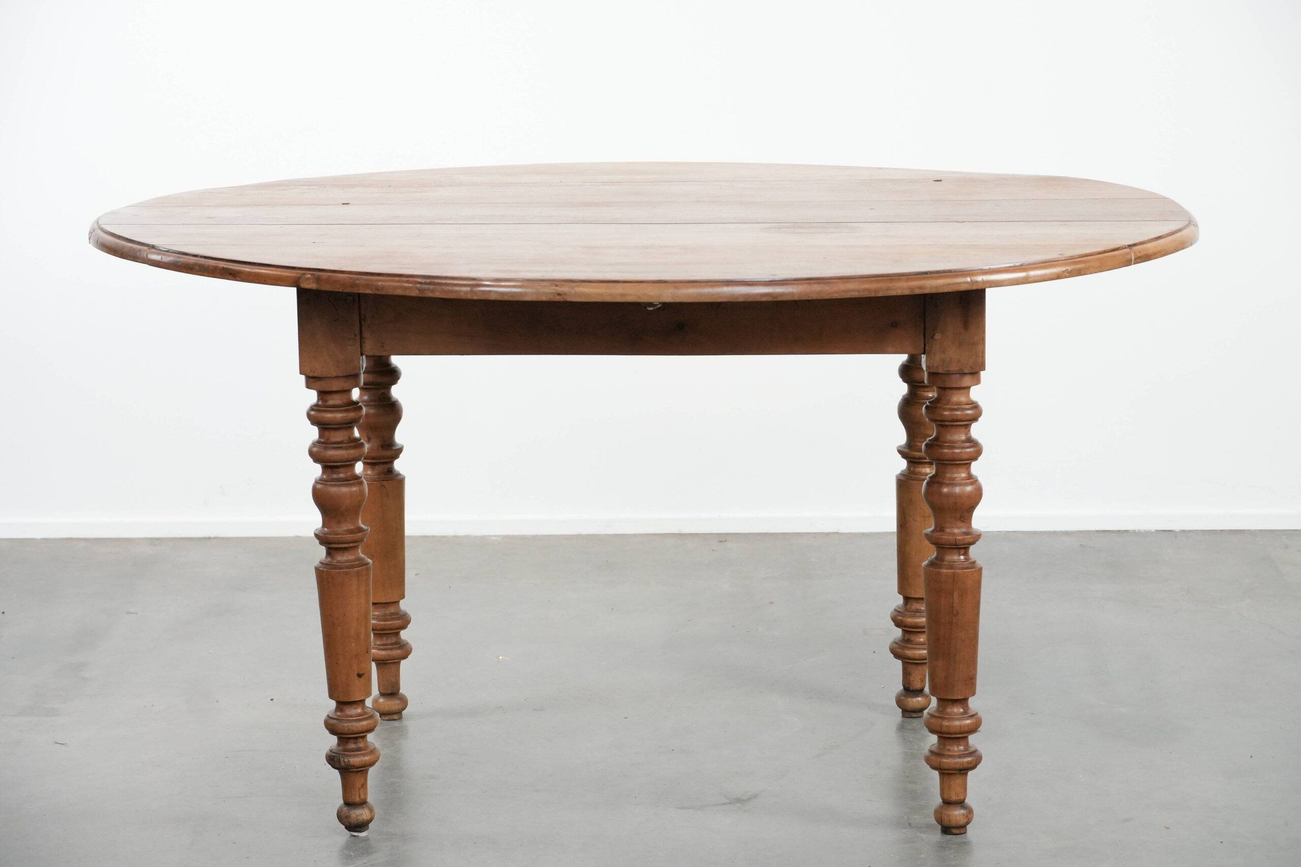 Antique English drop-leaf dining table made of walnut with elegant legs