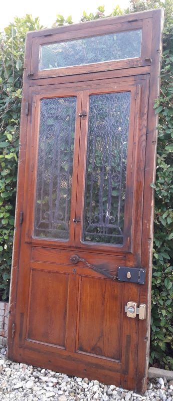 Oak entrance door and its frame and transom, wrought iron gates