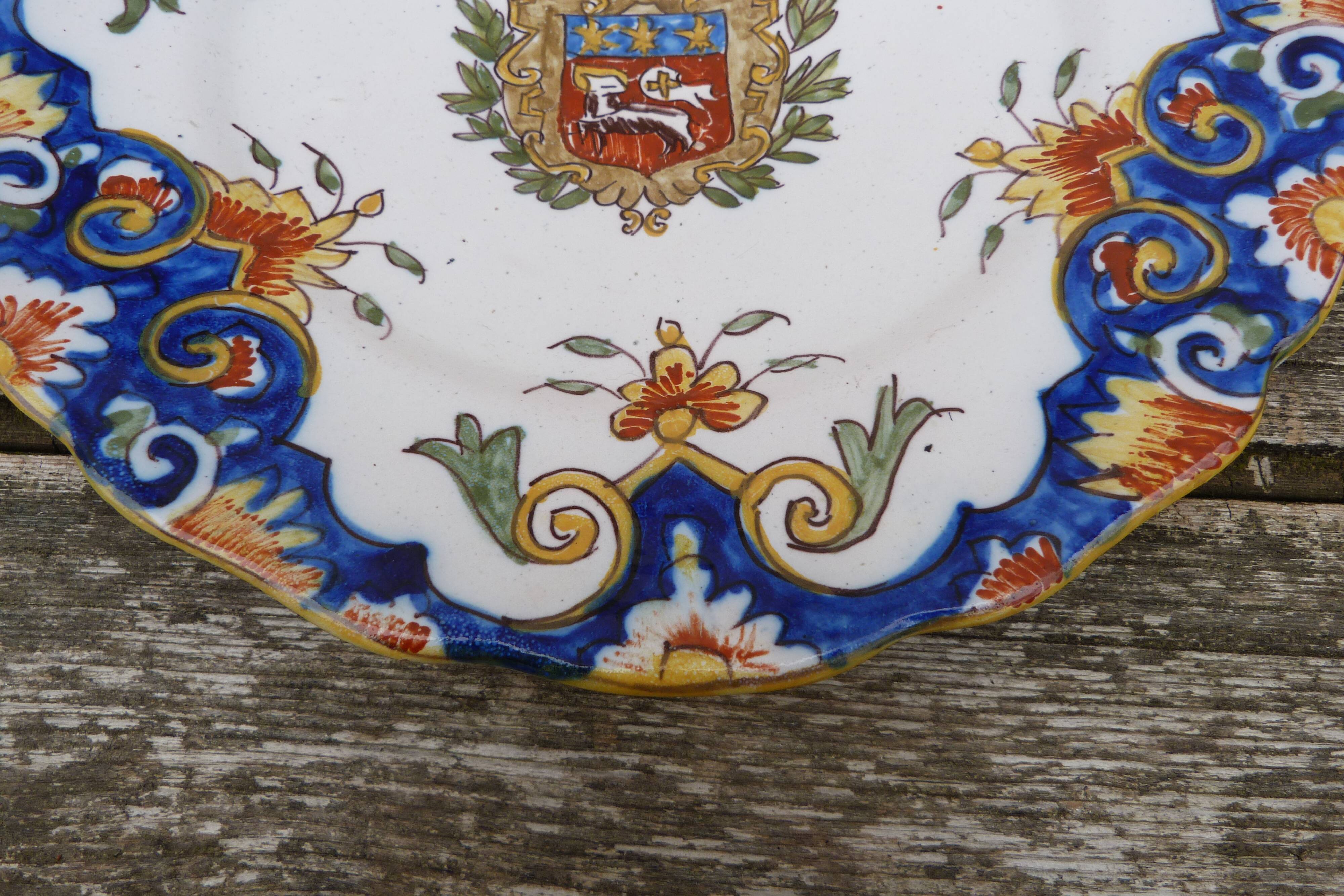 18th century plate in Rouen's faience with coat of arms and floral motifs