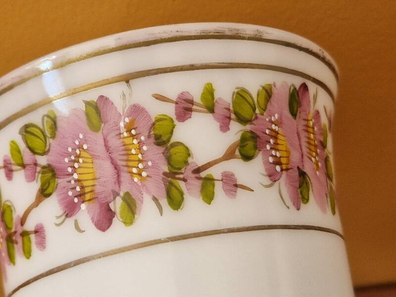 Footed glass in the shape of a chalice in white opaline with a floral decoration.