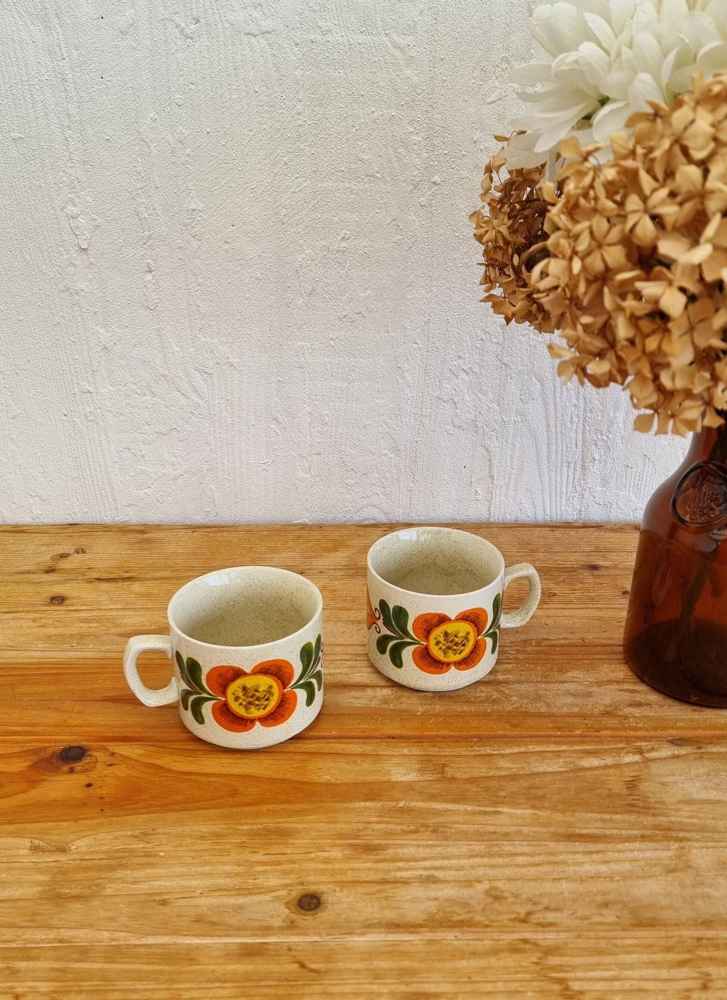 A pair of vintage Weidmann cups with an orange flower motif from the 1970s.