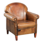 Fauteuil en peau de mouton avec un beau look vintage et une finition cloutée décorative.