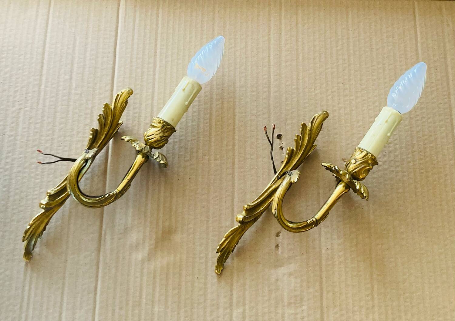 Bronze wall lights in the Louis XV style with curved branches and leaf decorations.