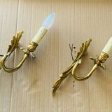 Bronze wall lights in the Louis XV style with curved branches and leaf decorations.