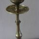 Brass candle holder with flowers and round shape.