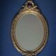 19th century oval gilded mirror, torch & quiver 106cm