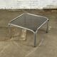 Table basse design vintage en verre fumé avec structure tubulaire