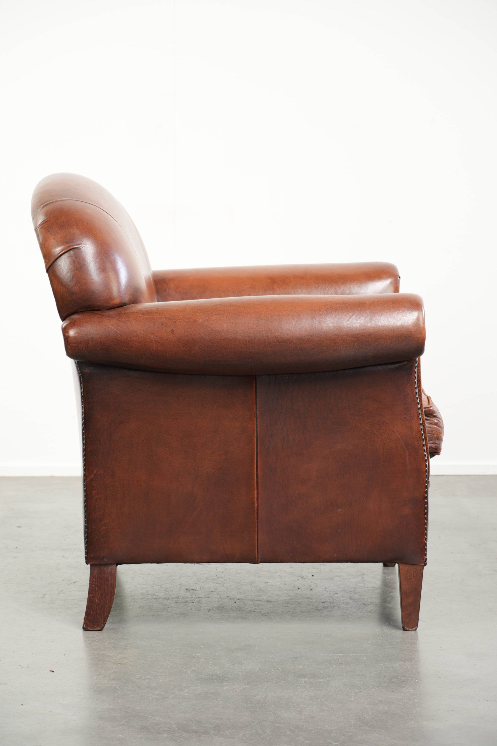 Sheepskin armchair with comfortable seat and finished with decorative nails