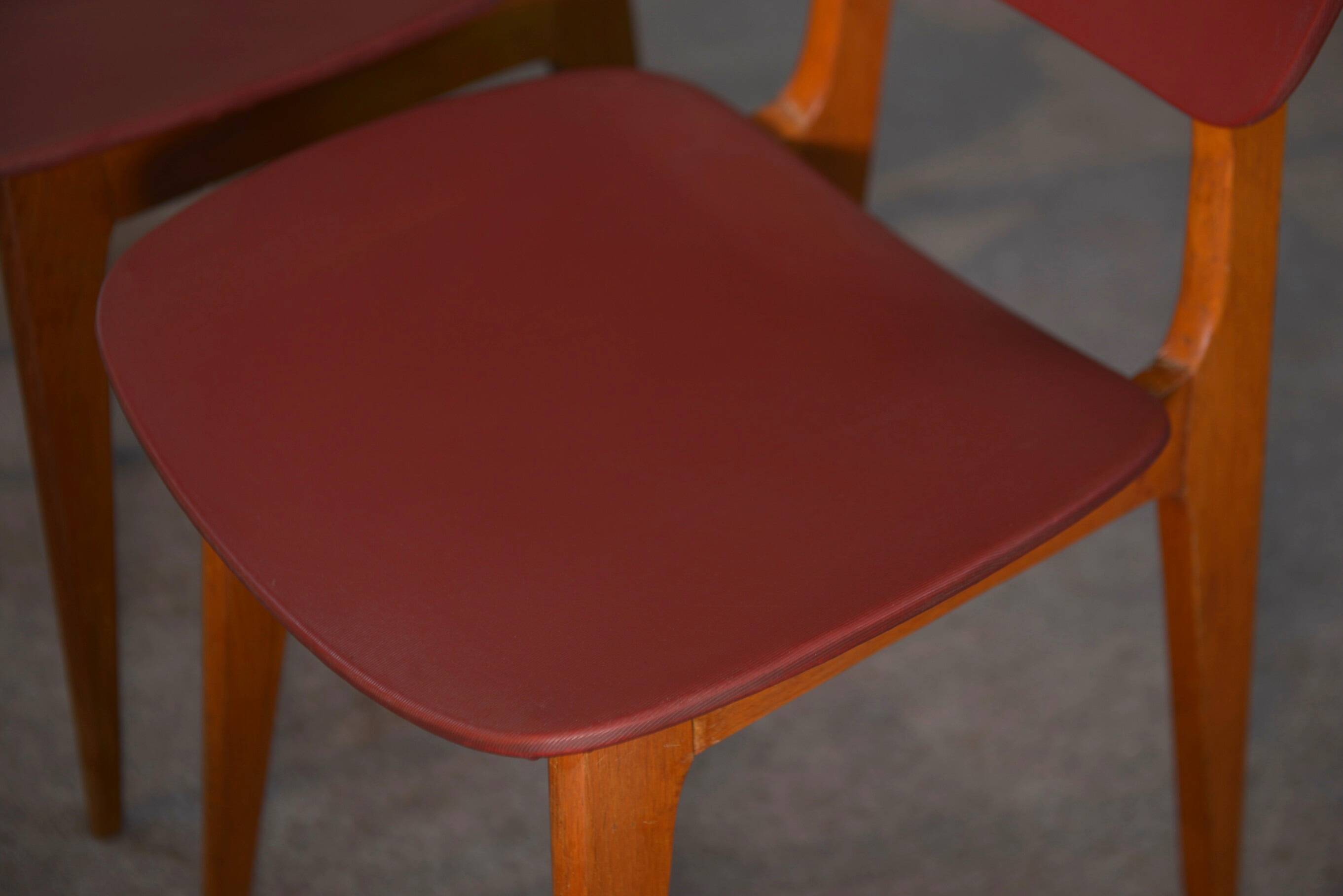 Set of 4 designer chairs in oak and red leatherette from the 1960s