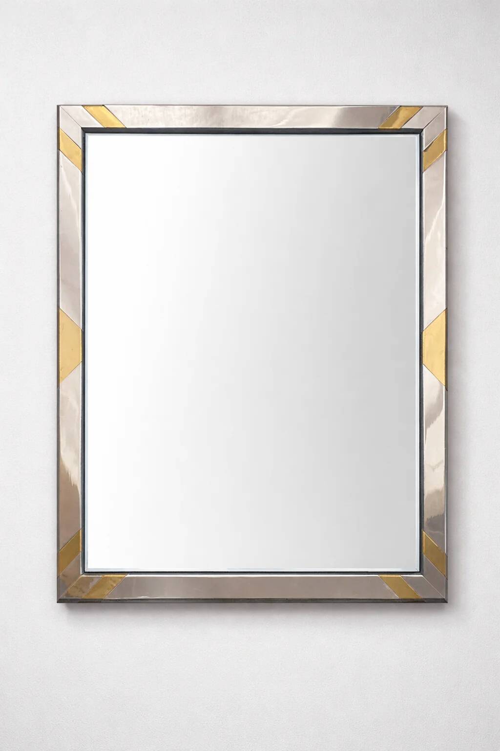 Faceted modernist wall mirror in steel and brass, geometric mixed metal frame 1970s.