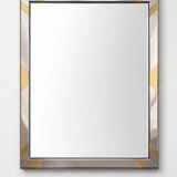 Faceted modernist wall mirror in steel and brass, geometric mixed metal frame 1970s.
