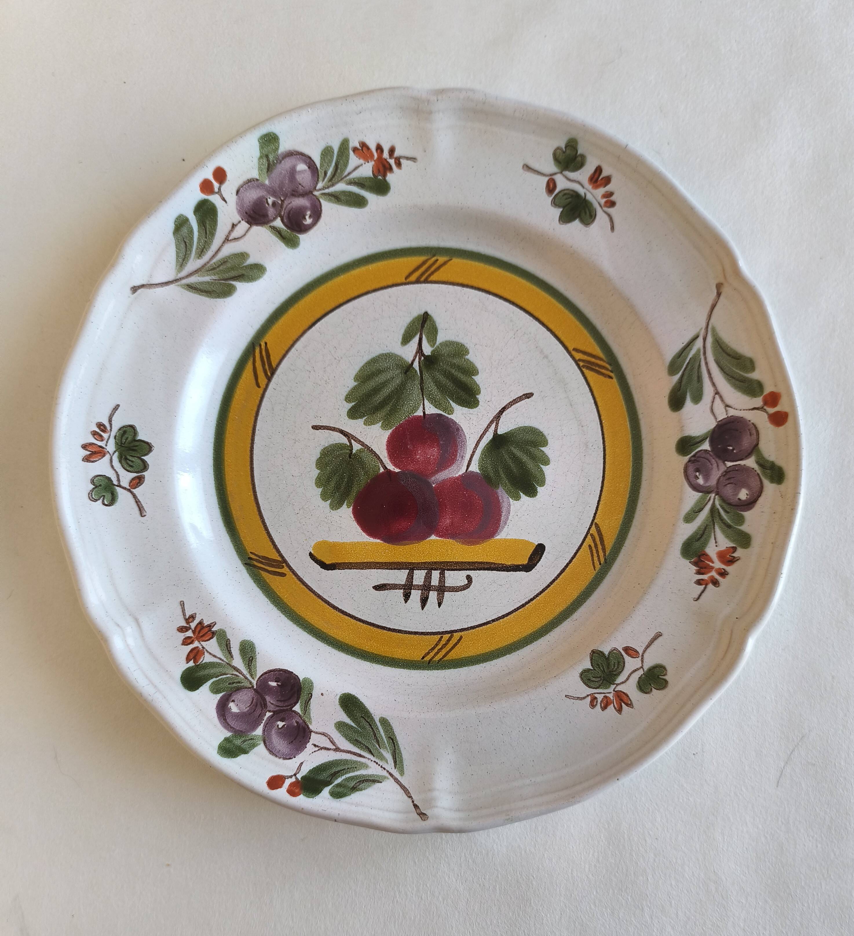Two earthenware plates with fruits, pears and plums.