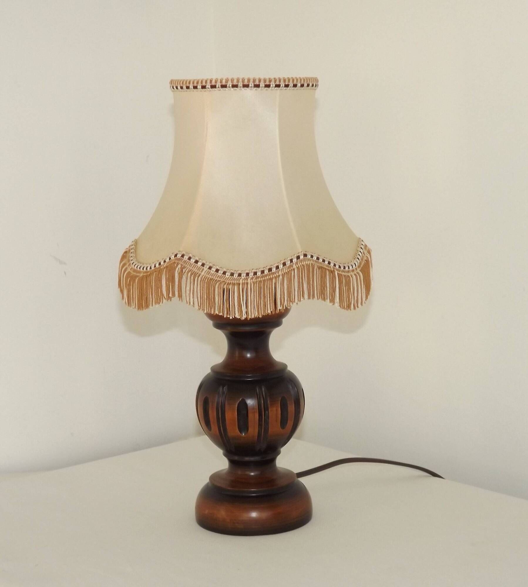 Mid-century French table lamp made of turned carved wood with a fringed shade.