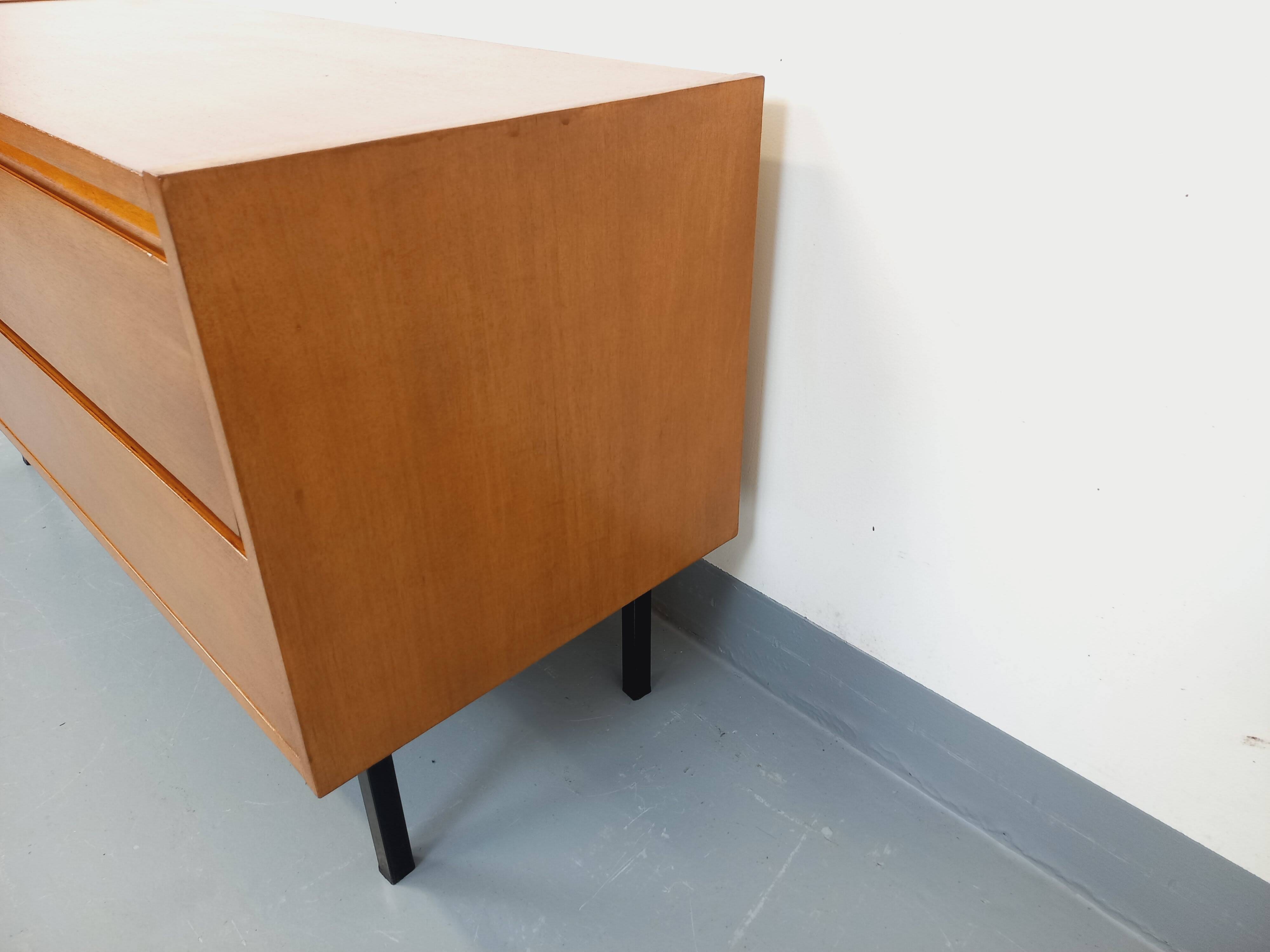 Small vintage Scandinavian sideboard in modernist style made of light oak wood.