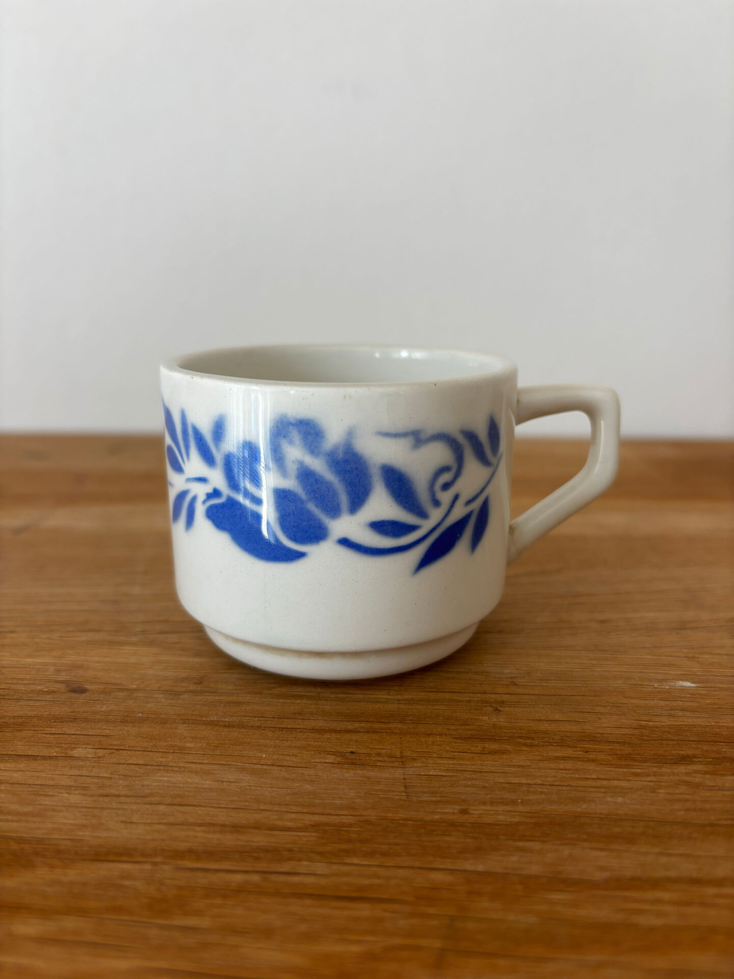 Set of 2 antique earthenware cups with blue floral pattern.